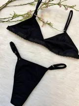 Conjunto de ropa interior negro de algodón, compuesto por un bralette triangular con breteles regulables y una tanga colaless regulable.