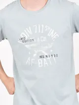 Remera verde con estampado circular con texto y alas.