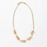 Collar dorado con cadena de eslabones y cuentas de cristal color durazno.