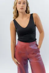 Pantalón de lino con acabado metalizado tornasolado, que refleja tonos entre rosa y lila según la luz. De corte recto y largo ¾, tiene cintura con elástico en la espalda que aporta comodidad y un calce relajado.