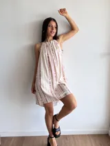 Vestido corto blanco con estampado tie-dye en tonos rosados, de corte suelto y breteles finos.