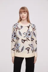 Sweater de punto color crema con estampado de flores azules y marrones.