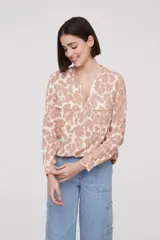 Blusa blanca de manga larga y corte holgado con escote en V y bolsillos frontales.
