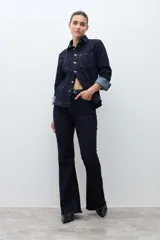 Camisa de jean de manga larga, color azul oscuro, con cuello camisero, botones frontales y bolsillos en el pecho.