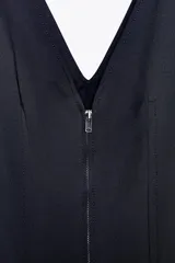 Vestido midi azul marino confeccionado en hilatura con algodón. Escote pico y tirantes anchos. Bajo evasé. Cierre frontal con cremallera metálica.