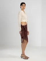 Camisa negra de manga larga con lazo en la cintura y botones nacarados. Confeccionada en 100% algodón y detalle de Polonio en cobre.