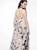 Vestido largo de breteles finos confeccionado en viscosa crinkled con estampa de manchas. De escote en V y silueta evasé, tiene una caída fluida que acompaña el movimiento. El efecto arrugado del tejido le da textura y carácter a una prenda fresca y versátil.