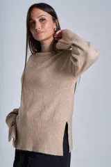 Sweater color crema de media polera, corte holgado y mangas largas. Tejido de punto con detalles acanalados en cuello, puños y ruedo.