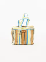 Bolso playero tipo tote bag a rayas horizontales en tonos naranja, amarillo, blanco y violeta. Tiene doble asa corta y cierre superior con cremallera. Incluye un dije colgante y una etiqueta de cuero sintético con el logo de la marca.