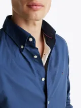Camisa azul de popelín de algodón con tecnología Flex, cuello abotonado, puños redondeados con botón, logo de Tommy Hilfiger bordado en el pecho y corte regular.