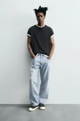 Pantalón de jean gris oscuro, corte amplio, con cinco bolsillos, efecto lavado y cierre frontal con cremallera y botón.