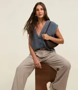 Pantalón wide leg de vestir color beige, con cintura alta, trabillas para cinturón, pliegues frontales y bolsillos laterales.
