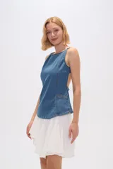 Top de jean azul con breteles finos, cuello redondo, pinzas y bolsillos frontales. Cierre con broches en la espalda. Corte al cuerpo.