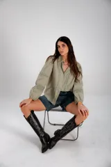 Camisa color verde oliva con detalles de encaje en el frente y en las mangas largas abullonadas.