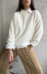 Sweater color crema de tejido de punto con trenzas verticales.
