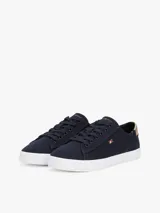 Zapatillas Tommy Hilfiger de lona azul marino con suela blanca de goma y talón dorado metalizado.