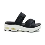 Sandalias negras con plataforma blanca y suela con burbujas de aire. Presentan dos tiras anchas cruzadas sobre el empeine y una tira ajustable con hebilla en el tobillo.