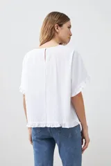 Blusa blanca con volados en mangas y ruedo.
