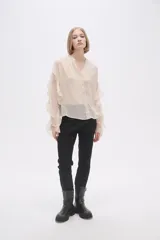 Camisa color crudo de poliéster con cuello mao y mangas largas con volados.