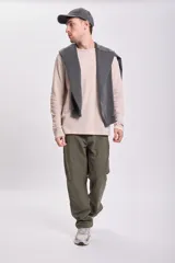 Pantalón verde de corte recto, estilo carpintero, con múltiples bolsillos y presillas para herramientas.