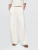 Pantalón deportivo de mujer color blanco hueso, de corte ancho y tiro alto.