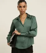 Camisa de manga larga color verde bosque, confeccionada en satén liso, con cuello inglés y cierre frontal de botones.