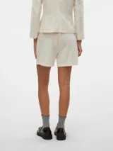 Short de tiro alto color blanco, estilo sastrero, con bolsillos laterales funcionales.