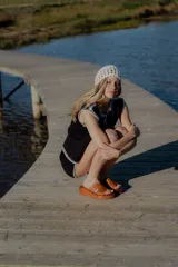 Conjunto tejido de algodón color celeste con terminaciones en marrón. Incluye un top sin mangas con botones y un short de tiro alto.