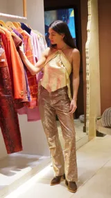 Top dorado de cuero con espalda de lino, corte irregular y cuello halter con detalle de caballito.