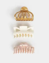 Set de tres broches para el pelo en diferentes formas y colores: uno dorado con efecto marmolado, uno blanco y uno rosa con estampado floral.
