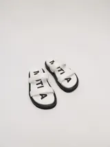 Sandalias blancas con doble tira ancha y plataforma negra.