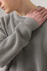 Sweater de punto gris con cuello redondo y textura tipo waffle.