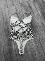 Malla entera con estampado animal print en blanco y negro, con breteles finos y escote pronunciado.