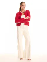 Chaqueta de mohair color rojo, con cuello redondo bordado con perlas y canutillos. Cierre frontal con broche interno, bolsillos simulados y apliques de brillos en la parte delantera.