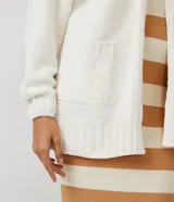 Chaqueta larga tipo cárdigan de chenilla color borgoña, con bolsillos delanteros, puños y bajo texturizados.