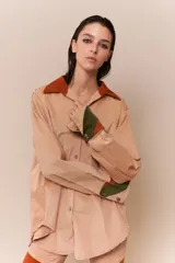 Camisa de corte holgado color beige, con detalles en colores contrastantes y mangas largas.