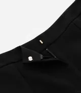 Bermuda de crepé color rojo, con pliegues frontales y botones decorativos en los bolsillos laterales.