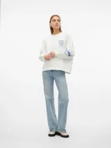 Sudadera blanca oversize con cuello redondo, hombros caídos, puños acanalados y estampado azul con la leyenda 'Tokyo Japan' en el pecho y letras en las mangas.