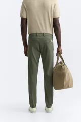 Pantalón chino azul marino, corte skinny fit, confeccionado en tejido de algodón con elasticidad. Cuenta con bolsillos frontales y traseros de vivo. Cierre frontal con cremallera y botón.