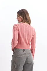 Sweater de punto color mostaza, con diseño de ochos y textura calada. Tiene cuello redondo, mangas largas y terminaciones acanaladas en puños y cintura.