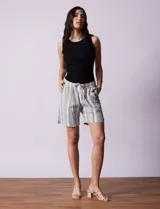 Short color beige de lino y rayón, con pretina elastizada, lazo de ajuste y bolsillos delanteros.