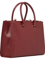 Cartera tote de Tommy Hilfiger color borgoña, con doble asa de mano y correa larga extraíble y ajustable. Tiene cierre magnético, dos compartimentos principales y tres bolsillos interiores con cremallera.