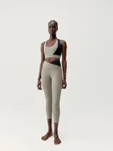 Top deportivo bicolor con asimetría, sujeción media-alta y tirantes cruzados. Confeccionado en tejido Shape_Tech con interior de mesh y copas extraíbles.