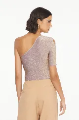 Blusa de fiesta color lila con brillos dorados, de un solo hombro y manga 3/4 con aberturas.