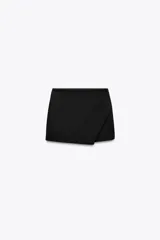 Falda pantalón corta negra de tiro medio con corte asimétrico.