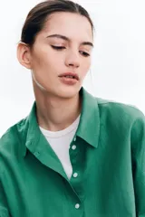 Camisa verde de lino y viscosa, de corte holgado, con cuello clásico, cierre frontal con botones y mangas 3/4.