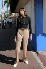 Pantalón negro de tiro alto con pernera recta, bolsillos frontales y falsos bolsillos con solapa en la espalda. Incluye cinturón marrón de cuero sintético.