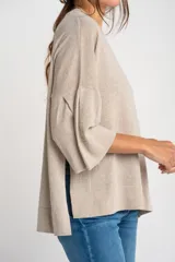 Sweater color cobre brillante, de tejido de punto con lurex, corte oversize, cuello redondo y mangas 3/4 con volados.