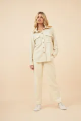 Camisa estilo leñador color beige con textura de espiga, de manga larga con puños abotonados, cuello clásico, cierre frontal con botones y dos bolsillos de parche con solapa abotonada en el pecho.