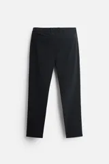Pantalón negro de corte slim fit, confeccionado en tejido elástico. Cuenta con cintura elástica, bolsillos frontales y traseros de vivo. Cierre frontal con cremallera y botón.